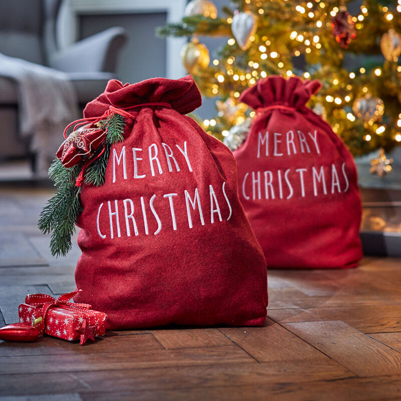 Emballer avec élégance de petits et grands cadeaux de Noël dans un sac en tissu