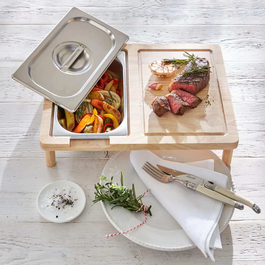 Holztablett mit Edelstahleinsatz für Gemüse und aufgeschnittenem Steak auf separatem Schneidbrett.