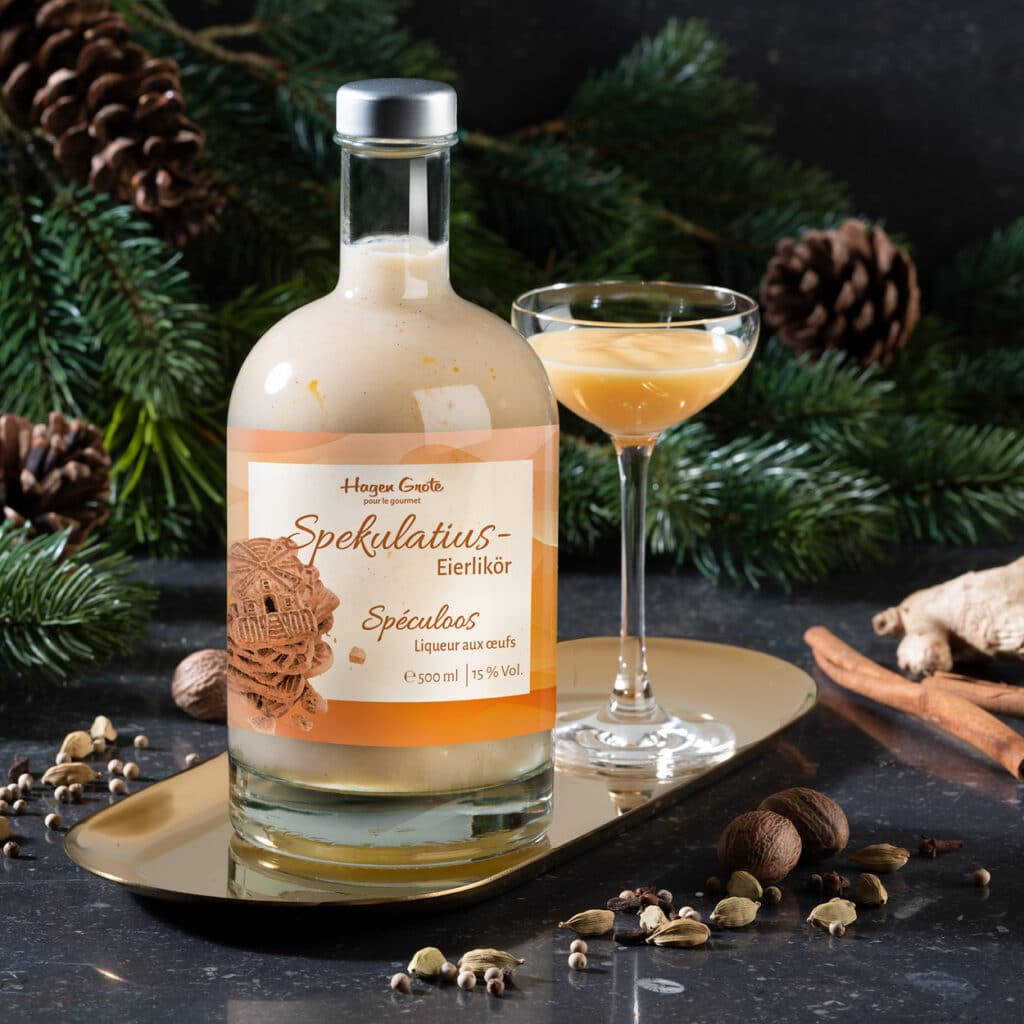 Spekulatius Eierlikör in festlicher Flasche mit Glas, weihnachtlich mit Gewürzen dekoriert