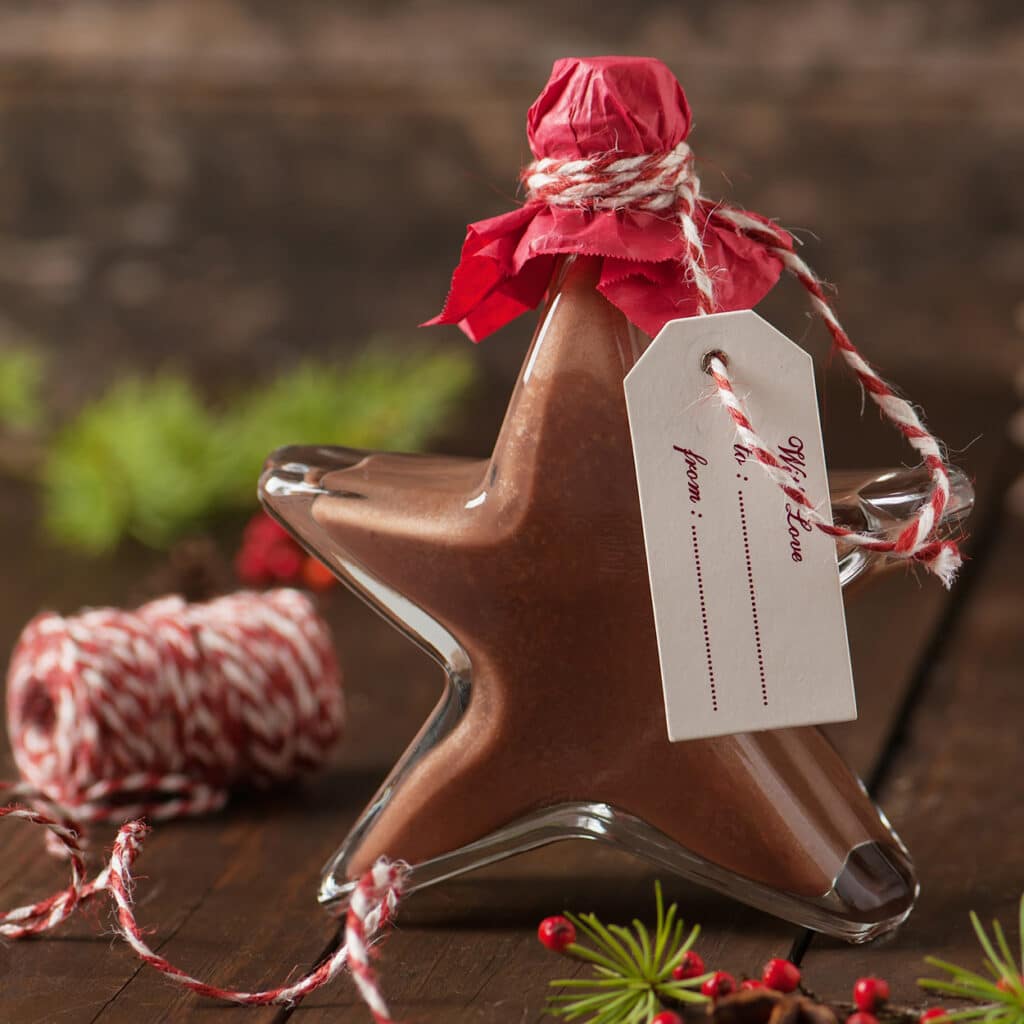 Sternförmige Flasche mit Schokoladenlikör und Geschenkanhänger, weihnachtlich dekoriert